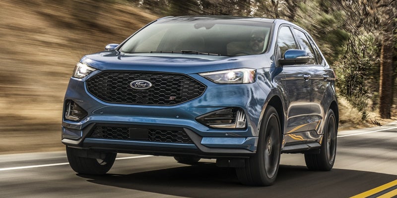 Front view of a blue 2021 Ford Edge being driven on the highway. | Ford dealer in Jacksonville, AR.