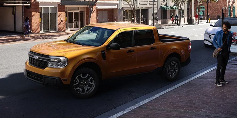 A golden orange 2022 Ford Maverick parked in the street. | Ford dealer in Jacksonville, AR.