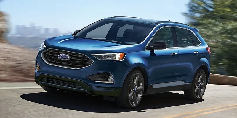 A blue 2022 Ford Edge being driven on the highway. | Ford dealer in Jacksonville, AR.