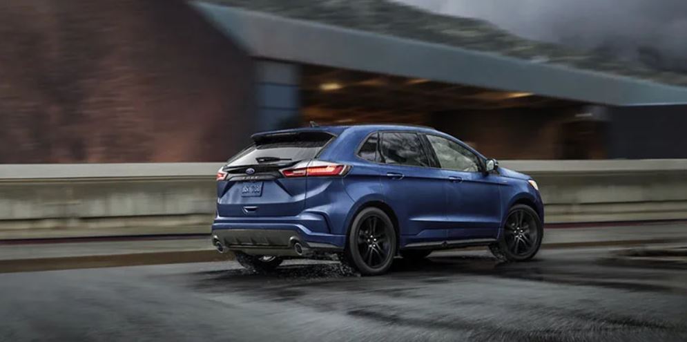 A blue 2022 Ford Edge being driven on the highway in the rain. | Ford dealer in Jacksonville, AR.
