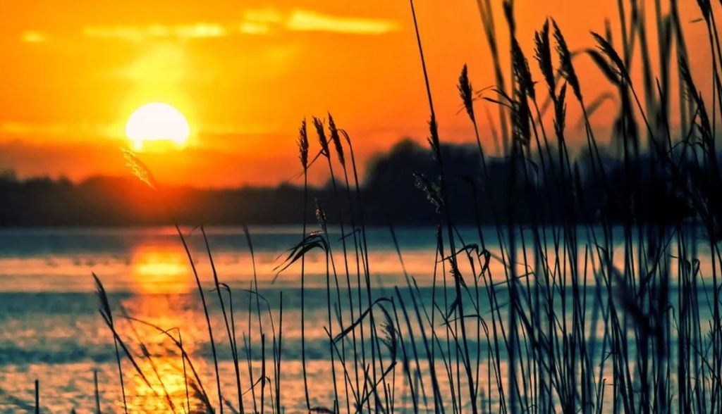 A lake with the sun setting in the background. | Landmarks near Jacksonville, AR.