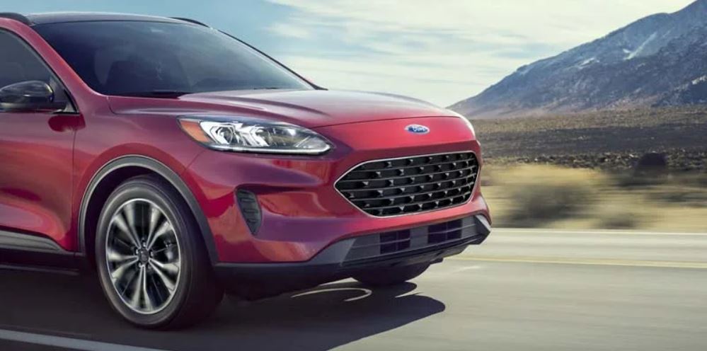 Front profile view of a red 2022 Ford Escape being driven on the highway with mountains in the background. | Ford dealer in Jacksonville, AR.
