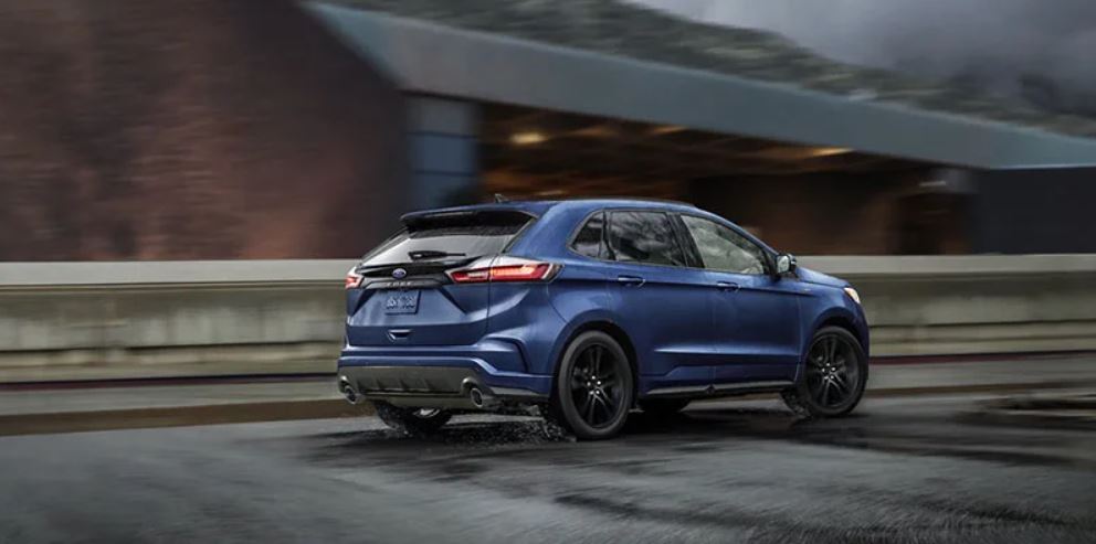 Profile view of a blue 2022 Ford Edge being driven on the road. | Ford dealer in Jacksonville, AR.