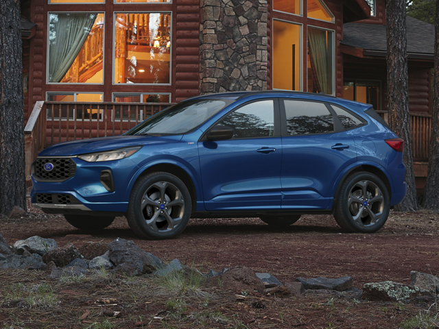 Profile view of a blue 2023 Ford Escape parked in front of a cabin in a wooded area. | Ford dealer in Jacksonville, AR | Crain Ford of Jacksonville